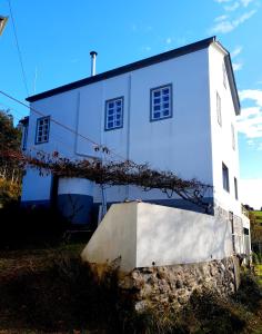 a white building with a staircase in front of it at Casa Natura Galicia in Santa María La Mayor del Rosario