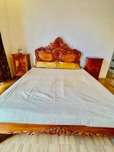 Schlafzimmer mit einem großen Bett mit einem Kopfteil aus Holz in der Unterkunft Vacation House 3-Bedroom Pangasinan Oasis in Pozorrubio