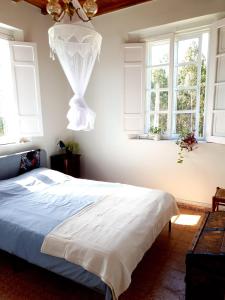 1 dormitorio con 1 cama y 2 ventanas en Casa Natura Galicia, en Santa María La Mayor del Rosario