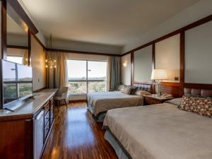 um quarto de hotel com duas camas e uma televisão de ecrã plano em Bourbon Cataratas do Iguaçu Thermas Eco Resort em Foz do Iguaçu