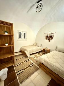 a bedroom with two beds and a clock on the ceiling at 3-Cozy Bedroom Haven l Free Horseback Tours in Cairo