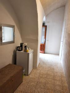 a hallway with a room with a table and a window at Stone Rooms in Matera