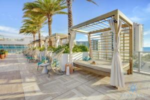 un balcón con sillas y palmeras en un edificio en Luxury 3 BR Stunning View & High Floor Hot Tub, en Hollywood