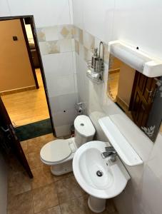 uma casa de banho com um WC branco e um lavatório. em SECRET D'OFÈ em Porto Novo