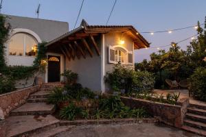 een huis met een lichtje ervoor bij Serene Seaside Bliss - Lush & Secluded Garden Oasis in Kalamata