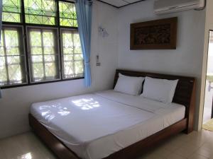 a bedroom with a large bed in a room with windows at Bangpo Village in Ban Bang Po