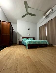 um quarto com uma cama e uma ventoinha de tecto em SECRET D'OFÈ em Porto Novo