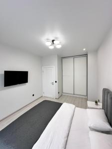 um quarto com uma cama e uma televisão de ecrã plano em Luxury Apartments Prestige em Uzhhorod