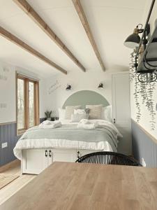 a bedroom with a large bed and a tv at Hidden Gem Luxury Shepherd Hut - Pea Pod in Wimbish