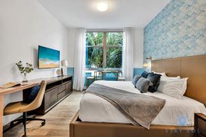 a bedroom with a large bed with a desk and a desk at Best Stay - Rooftop Pool & Hot Tub - Hollywood Beach in Hollywood