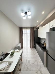 uma cozinha com uma mesa branca e um frigorífico em Luxury Apartments Prestige em Uzhhorod