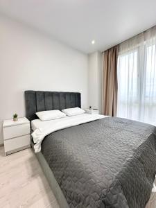 um quarto com uma cama grande e uma janela em Luxury Apartments Prestige em Uzhhorod