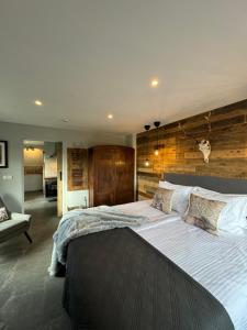 a large bedroom with a large bed with a wooden wall at Framptons Apartments Garden & Spa - Dla dorosłych i dzieci 12 plus - Adults and children 12 plus in Murzasichle
