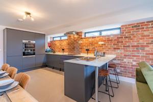 cocina con pared de ladrillo y encimera en Norton Coach House, en Cheltenham