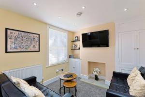 a living room with a couch and a flat screen tv at City Centre Riverside Retreat in Kent