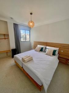 um quarto com uma grande cama branca e uma luz em Socco Hostel em Tânger
