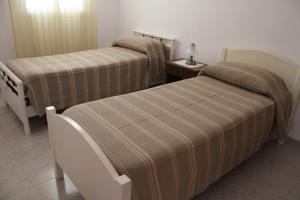 サンタンドレーアにあるcasa bluのベッド2台、テーブル(ランプ付)が備わる客室です。