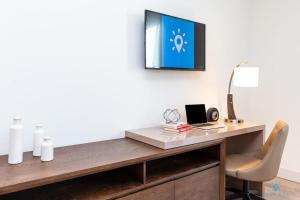 a desk with a chair and a tv on a wall at Amazing Pool - Gym - Hot Tub - Near Beach in Hollywood