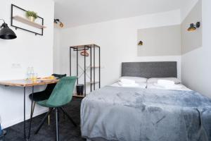 a bedroom with a bed and a desk with a green chair at Stilvolle Apartments in Bonn I home2share in Bonn