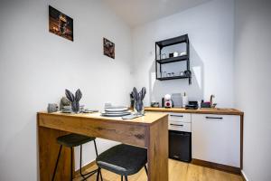 a kitchen with a wooden desk and two stools at Apartments Portarata in Pula
