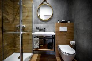 a bathroom with a sink and a toilet and a mirror at Apartments Portarata in Pula
