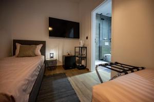 a bedroom with two beds and a television on the wall at Apartments Portarata in Pula +8 photos