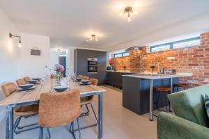 cocina y comedor con mesa larga y sillas en Norton Coach House, en Cheltenham 17 fotos más
