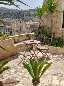 een tafel en 2 stoelen op een patio met uitzicht bij Borgo Hedone in Scicli