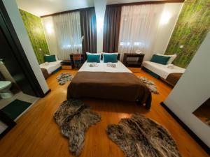 een slaapkamer met 2 bedden en 2 tapijten bij Motel Krnjevo in Krnjevo