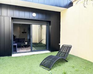 a chair sitting on the grass in front of a house at Residence Belfort in Le Mans