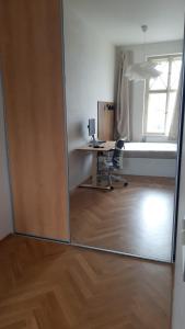 einen Spiegel in einem Büro mit einem Schreibtisch und einem Fenster in der Unterkunft Harmony Residence One in Prag