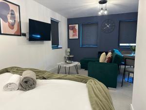 a bedroom with a bed and a living room at Newark House Premium Apartments by DH ApartHotels in Peterborough