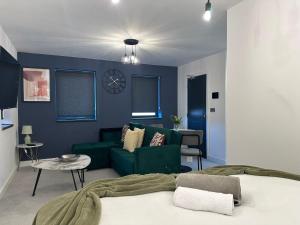 a living room with a green couch and blue walls at Newark House Premium Apartments by DH ApartHotels in Peterborough