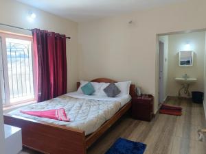 um quarto com uma cama grande e cortinas vermelhas em QUEENS COTTAGE - individual cottage em Ooty