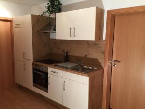 uma cozinha com armários brancos e um lavatório em Appartements Funk em Pfungstadt