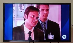 a television screen with two men in suits on it at Hotel Alto Amazonas in Leticia