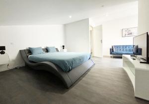 ein Schlafzimmer mit einem Bett und einem blauen Sofa in der Unterkunft Residence Belfort in Le Mans