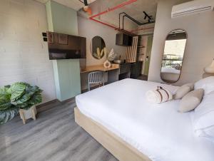 um quarto com uma grande cama branca e uma cozinha em Urbit Social Lofts em Medellín