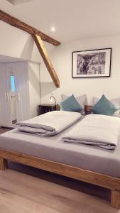 ein großes Bett mit weißer Bettwäsche und blauen Kissen in der Unterkunft Heimatliebe Wohnung FÜNF in Erfweiler