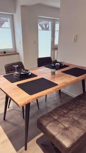 einen Holztisch mit schwarzen Matten auf einem Zimmer in der Unterkunft Heimatliebe Wohnung FÜNF in Erfweiler
