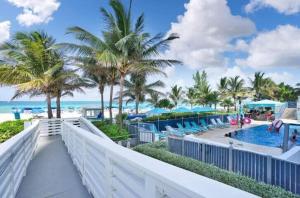 a view of the beach from the balcony of a resort at New Sunny Isles: Oceanview Comfort Stay in Aventura