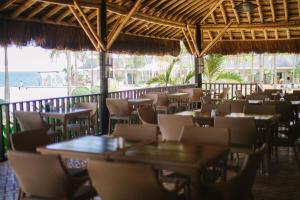 a restaurant with tables and chairs and the beach at Mangodlong Paradise Beach Resort in Camotes Islands