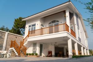 a large white house with a balcony at Green Villa - Ngôi Nhà Chung in Can Tho