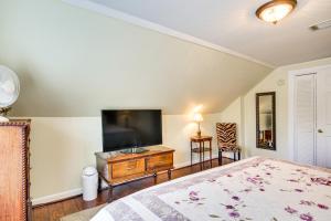 a bedroom with a bed and a flat screen tv at Aiken Apt with Garden-View Balcony Half-Mi to Dtwn! in Aiken