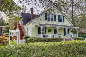 una casa gialla con persiane verdi e un portico di Aiken Apt with Garden-View Balcony Half-Mi to Dtwn! ad Aiken