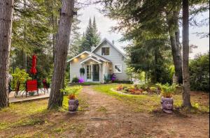 a white house with trees and a yard at L'Oasis Zen bord de L'eau & Spa in Nominingue