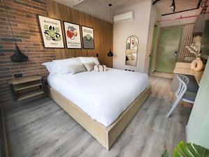 Urbit Social Lofts في ميديلين: سرير كبير في غرفة بجدار من الطوب