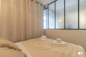 a bedroom with a bed with towels on it at MBA - Splendide Appartement Proche Montmartre in Paris +37 photos