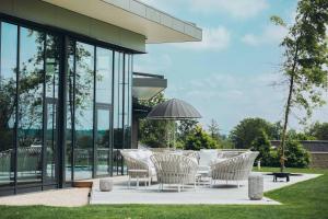 Le Bois d’Alice في Chanoz-Châtenay: فناء به كراسي بيضاء ومظلة