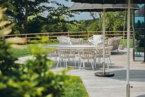 Le Bois d’Alice في Chanoz-Châtenay: طاولة وكراسي ومظلة على سطح السفينة